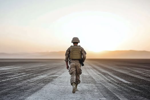 Soldier walks towards the horizon at dawn on a vast desert landscape. photo
