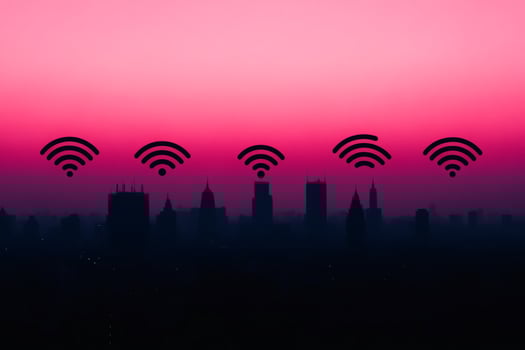 City skyline silhouette under a vibrant pink sunset with wifi symbols. photo