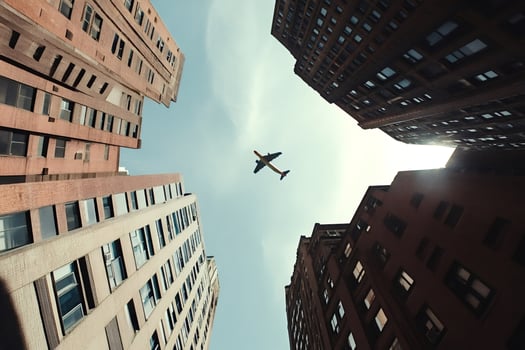 Airplane flying over skyscrapers in urban city center photo