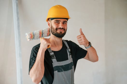 With painting roll.. The man is making repairs in the apartment photo