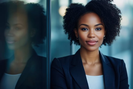 Confident Black Businesswoman Portrait Leaning Against Glass Wall with Reflection photo