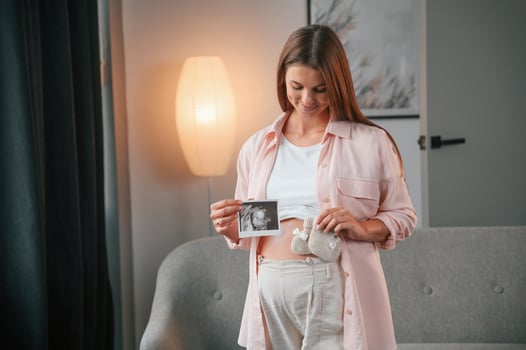 With ultrasonic diagnostis ,picture. Beautiful pregnant woman is indoors at home photo
