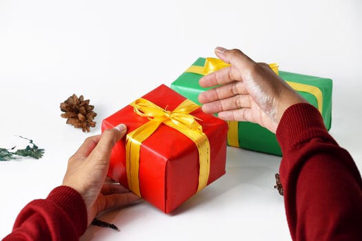 human hands holding colorful christmas gift boxes photo