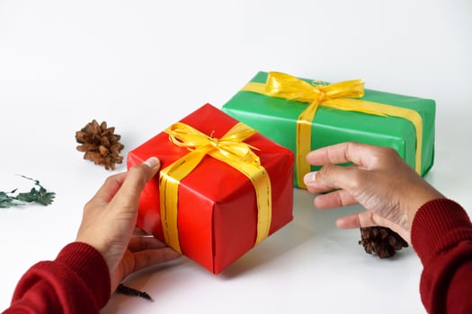 close up of hands holding red and green gift boxes photo