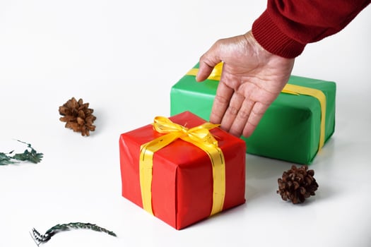 holding red and green holiday gift boxes with hands photo
