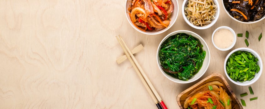 Korean food and chopsticks on wooden background, banner format photo