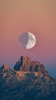 A full moon is seen over a mountain range photo