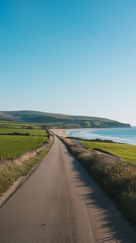 A long empty road with grass and ocean in the background photo