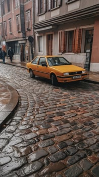 A yellow car parked on a cobblestone street photo