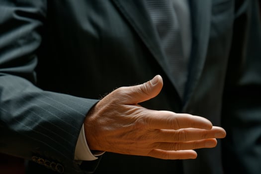 A close-up of a man's hand in a suit extending for a handshake, symbolizing agreement and professionalism. photo