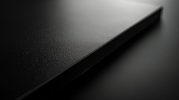 Close-up of a sleek, textured black surface, emphasizing minimalist design and elegance. photo