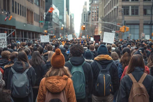A diverse group of protesters, mainly young adults, gather in a city street holding signs advocating for social justice. photo