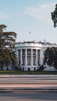 A white house with a large flagpole photo