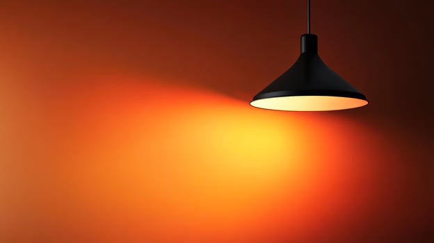 A stylish black lamp casting warm orange light on the wall. photo