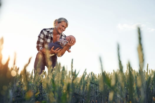 In the wheat. Happy woman ,on the agricultural field is with little baby in the hands photo