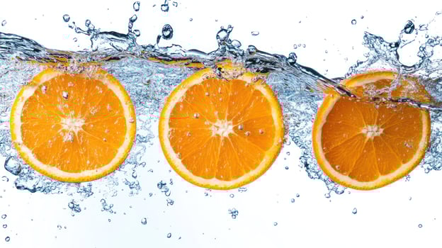 Three orange slices splashing in clear water, showcasing freshness. photo