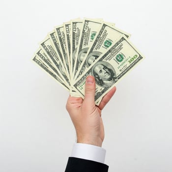 A man in a suit holding up a stack of money photo
