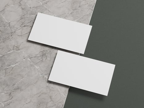 Clean business card mockup with two white cards aligned on a contrasting marble and green backdrop. photo