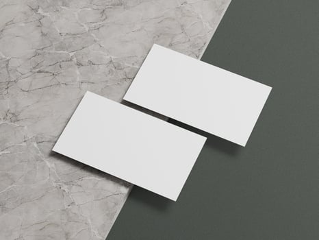 Modern business card mockup with two white cards positioned in a minimalistic layout on a marble surface. photo