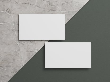 Stylish business card mockup with two white cards resting on a marble and dark green textured background. photo