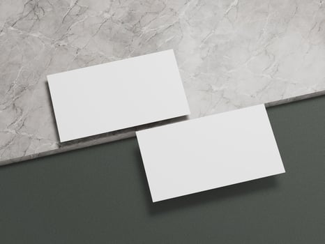 Contemporary business card mockup with white cards positioned elegantly on a marble and dark green background. photo