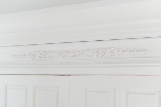 Ornate white crown molding with intricate floral details photo