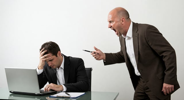 Two men in suits are arguing over a laptop photo