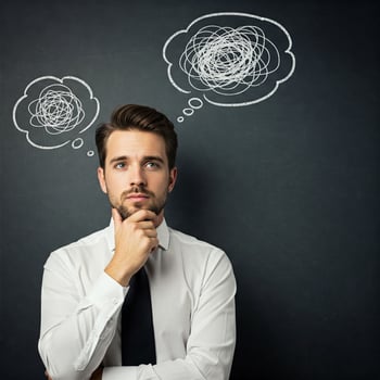 Young man thinking about something in his mind with thought bubbles above his head photo