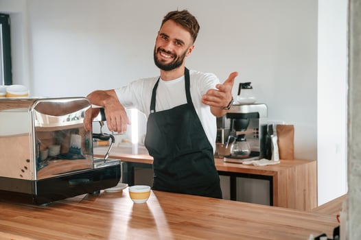 Beautiful, portrait. Cafe worker in white shirt and black apron is indoors photo