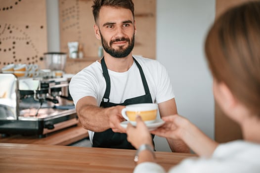 Customer,, takes her order from barista in the cafe photo