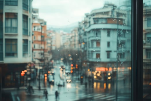 Viewing Rainy City Streetscape Through Window with Droplets and Reflections photo