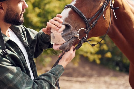 Young ,man with a horse is outdoors, photo