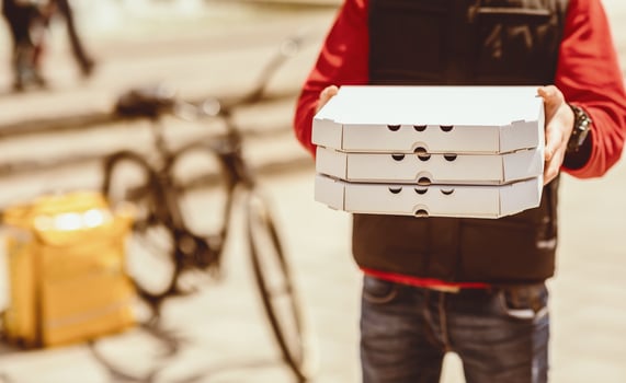 Unrecognizable Courier Offering Pizza Boxes To Camera Standing Near Scooter Outside. Restaurant And Cafe Delivery. Cropped, Empty Space photo