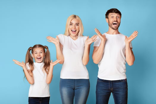 Joyful Surprise. Happy Parents And Daughter Screaming In Delight Over Blue Background In Studio. photo