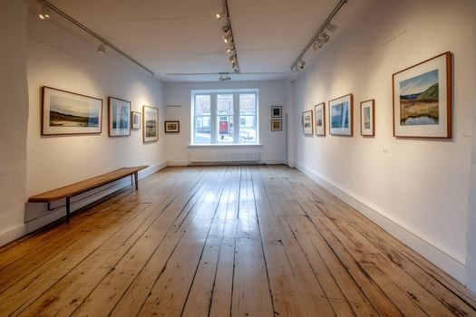 Art gallery interior showing landscape paintings and wooden floor photo