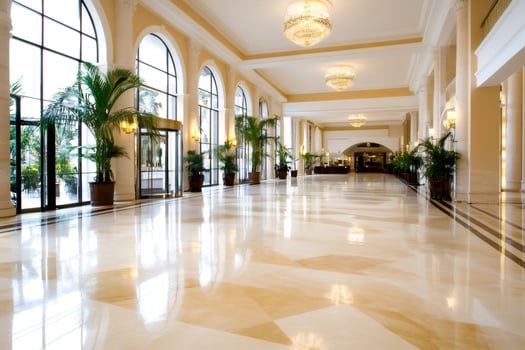 Elegant hotel lobby with marble floor reflecting light and chandeliers photo