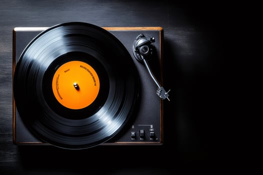 Vinyl record playing on vintage turntable with orange label on dark background photo