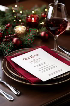 Christmas menu and red wine on elegant holiday table setting photo