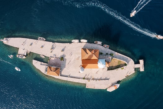 Motor boats sail the sea around the island of Gospa od Skrpjela. Montenegro. Top view photo