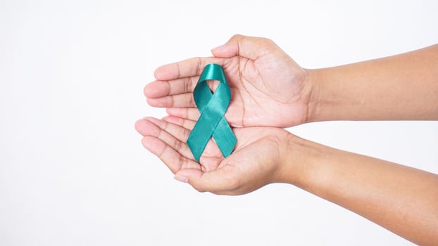 Green awareness ribbon in man hands isolated on white background photo