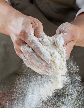 A person is sprinkling flour on a table photo