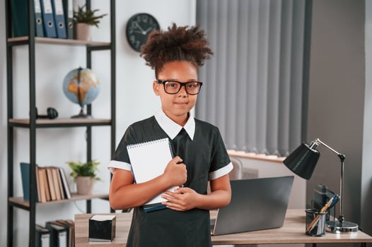 Ready for the school. Cute, little girl is standing indoors in domestic room photo