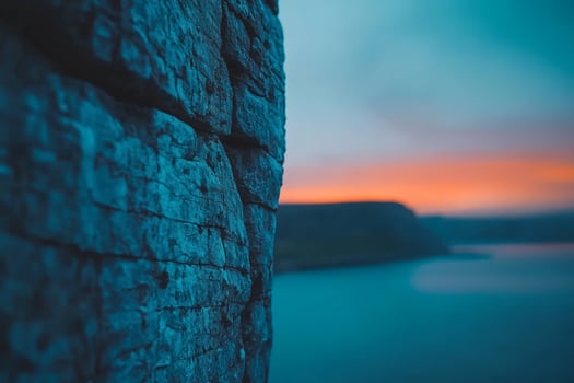 Vibrant sunset glimpsed through rugged cliffs photo