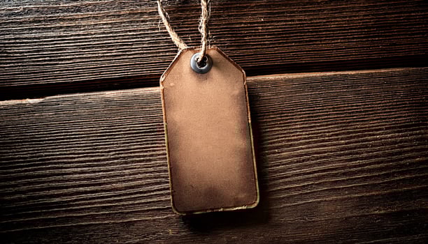 Blank Brown Tag Resting on Rustic Wooden Surface With Soft Lighting Highlighting Its Texture and Details photo