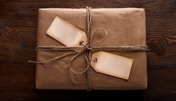 Wrapped Gift With Tags on Wooden Table, Waiting for Celebration or Event Delivery at Home, Highlighting Thoughtful Gifting Tradition photo
