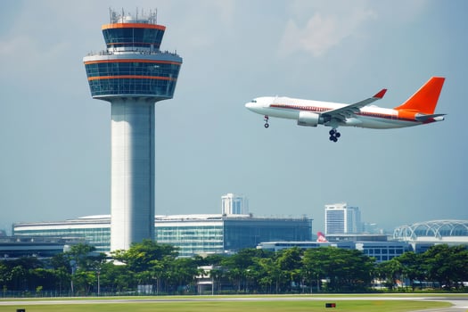 Airplane landing near airport control tower on sunny day photo