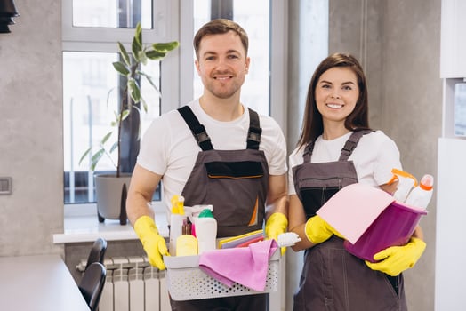 Cleaning company workers holding cleaning products smiling at home photo