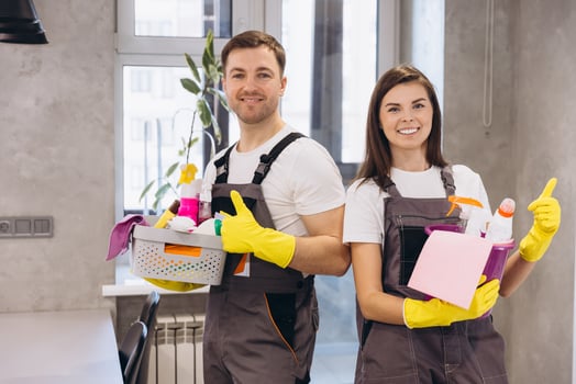 Cleaning company staff holding cleaning products showing thumbs up photo
