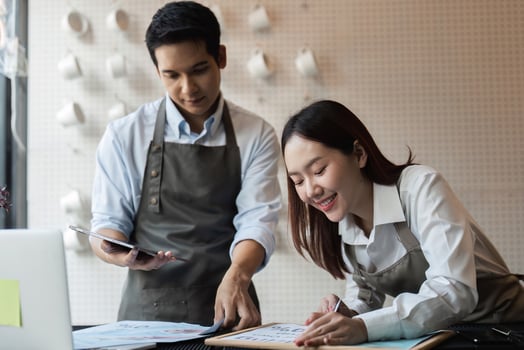 Planning and Coffee Shop Strategy. Baristas collaborating on promotional ideas for their cafe, focusing on innovative strategies to enhance customer engagement and service. photo