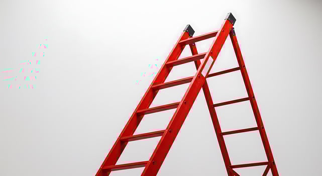 Red Ladder Against White Wall. A Symbol of Progress and Ambition photo